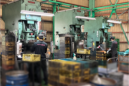 プレス機にワークを投入する作業風景